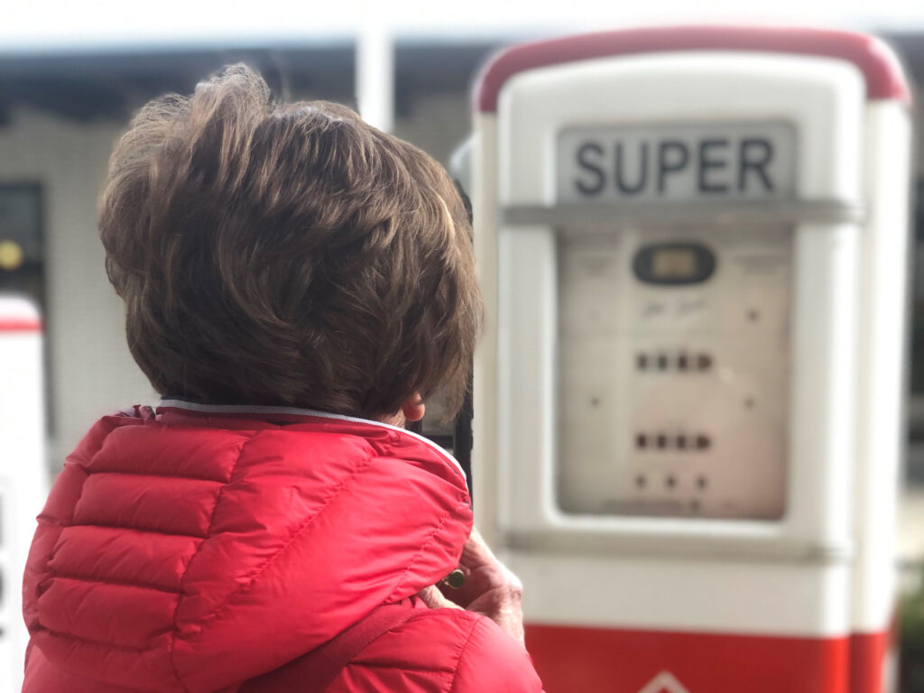 Bild mit Frau vor Tankzapfsäule